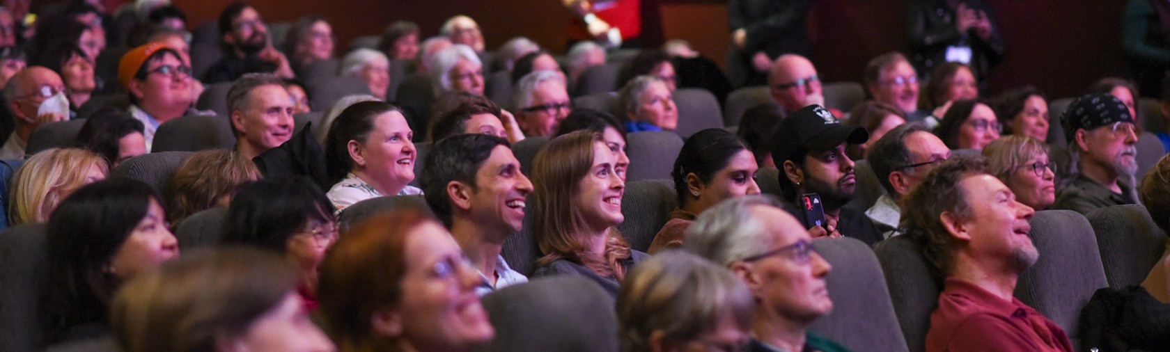 Indoor cinema audience laughing and smiling